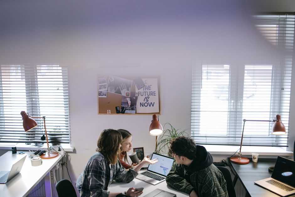 Two colleagues reviewing work on a laptop